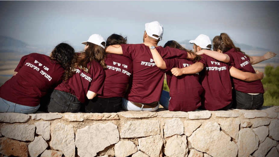 קבוצת מתנדבי שנת שירות יושבת מחובקת מול הנוף